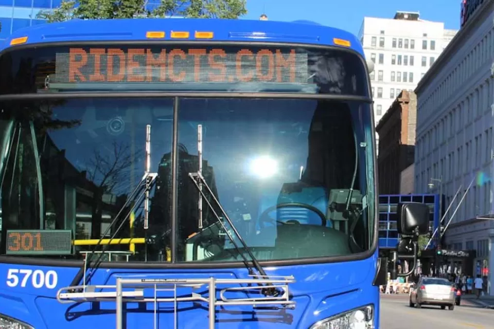Close-up of front of blue MCTS bus with "Ride MCTS" on marquee in urban Milwaukee neighborhood